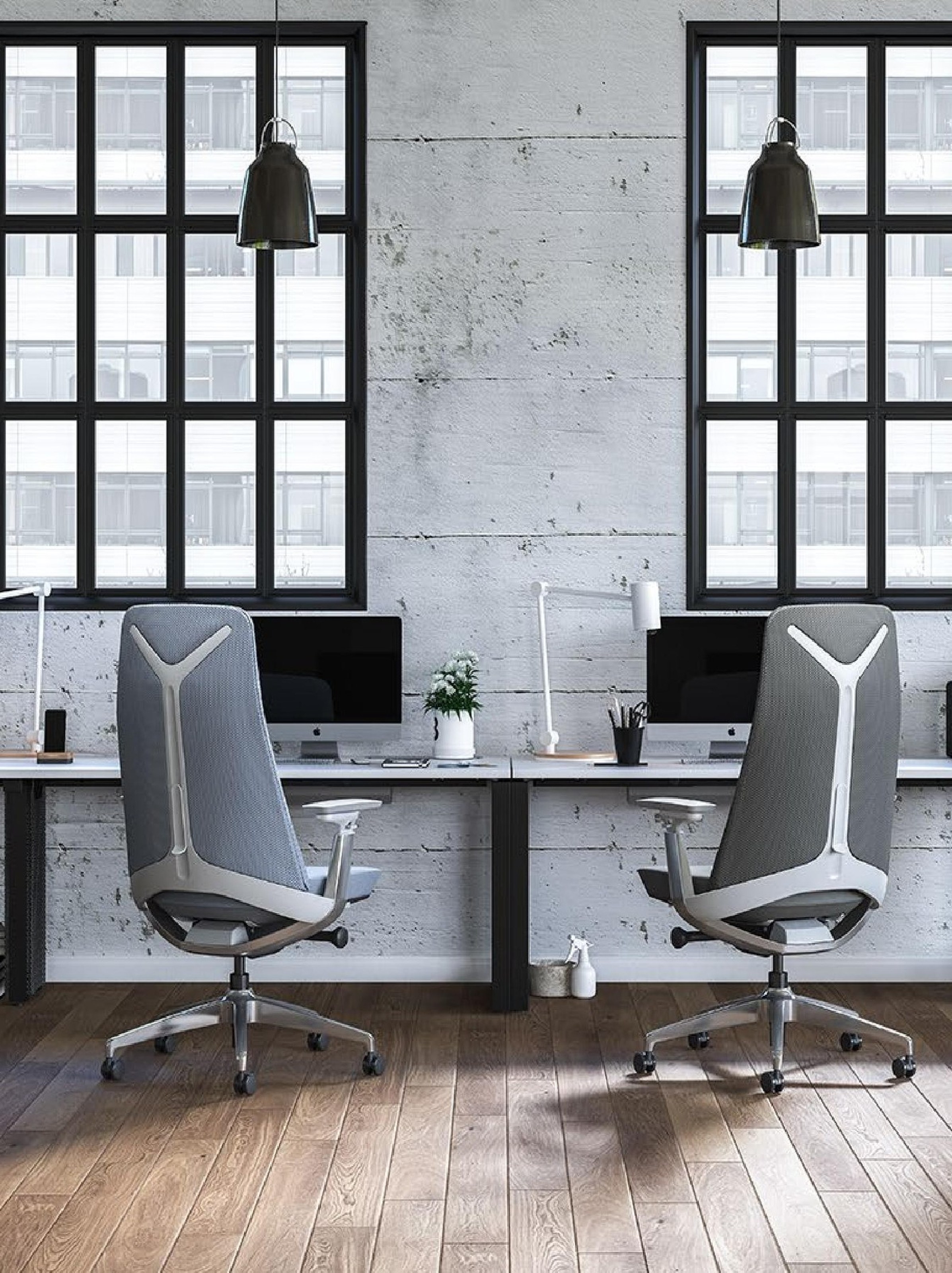 Two high-back task chairs at desks against an exposed-brick wall