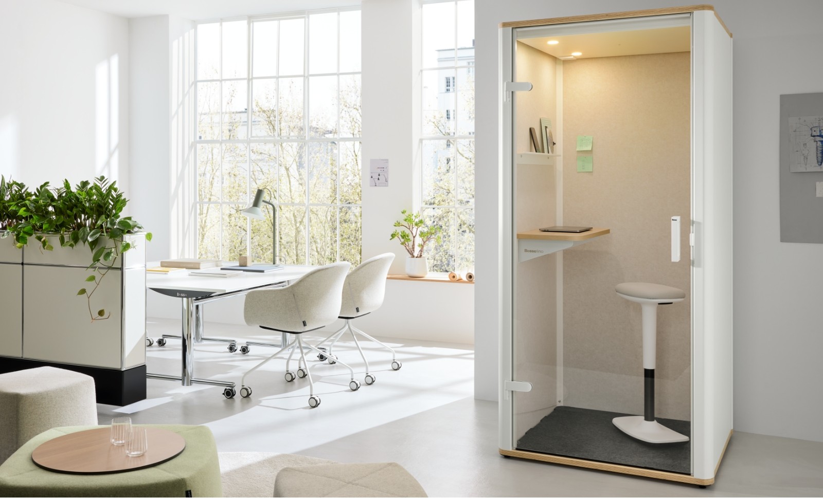 Bosselino call pod beside a bright, plant-filled meeting corner